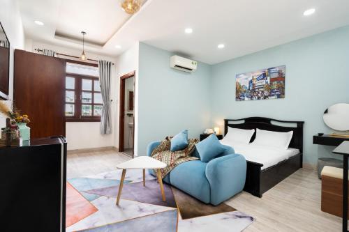 1 dormitorio con 1 cama y 1 sofá azul en The Lovenote Home en Ho Chi Minh