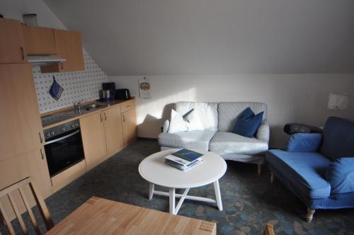 ein kleines Wohnzimmer mit einem Sofa und einem Tisch in der Unterkunft Ferienwohnung Bohlen 65265 in Moormerland
