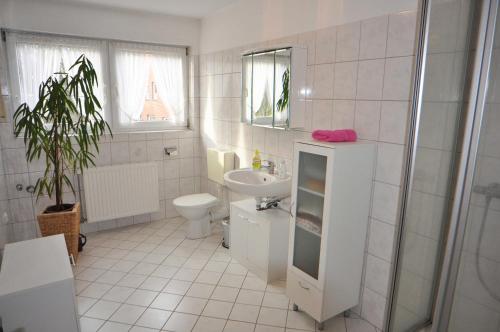 a white bathroom with a sink and a toilet at Ferienwohnung Bohlen 65265 in Moormerland