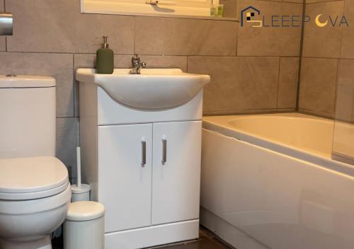 倫敦的住宿－Luxury & Spacious 2 Bedroom Flat Families Business Relocation SleeepOva Short Lets & Serviced Accommodation，浴室配有盥洗盆、卫生间和浴缸。