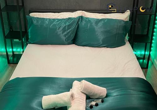 倫敦的住宿－Luxury & Spacious 2 Bedroom Flat Families Business Relocation SleeepOva Short Lets & Serviced Accommodation，绿色的床,上面有两只填充的动物