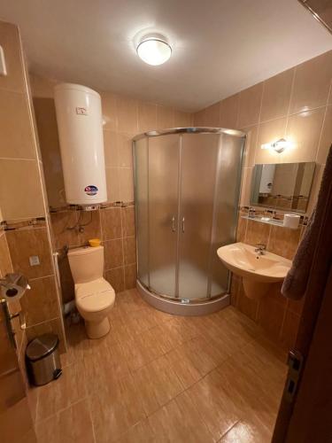 y baño con ducha, aseo y lavamanos. en Kavarna Paradise Apartments en Kavarna