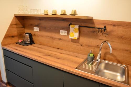 a kitchen with a sink and a wooden counter top at FloraVilla in Rajecké Teplice