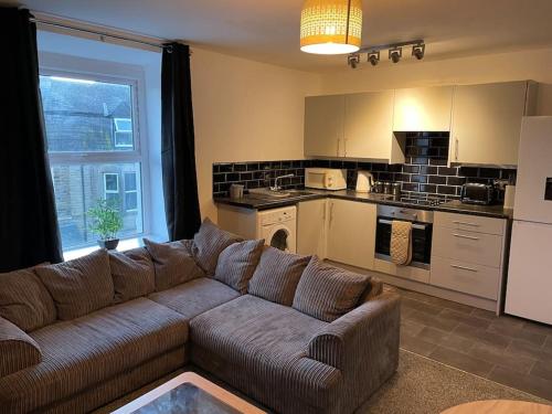 a living room with a couch and a kitchen at Apartment By The Sea! in Morecambe