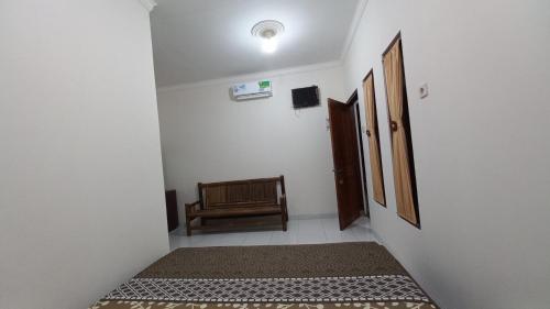 a hallway with a door and a chair in a room at Kumojoyo Homestay in Borobudur