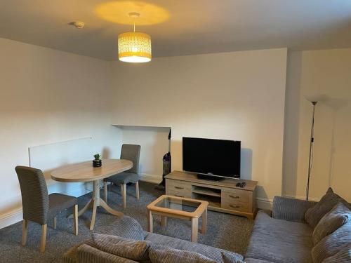 a living room with a table and a tv at Apartment By The Sea! in Morecambe
