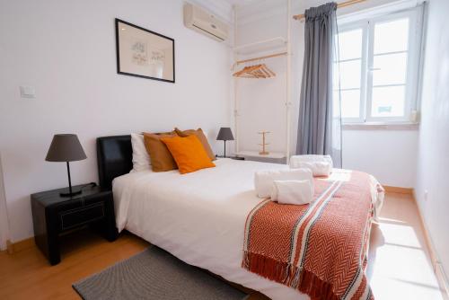 リスボンにあるAlameda Apartments & Roomsのベッドルーム1室(オレンジ色の枕と窓付)