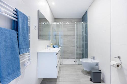 a white bathroom with a sink and a shower at The Hub central apartment Burgau in Burgau