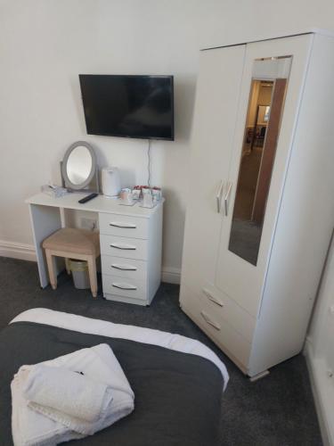 a room with a bed and a desk with a mirror at The Sanderling in Morecambe