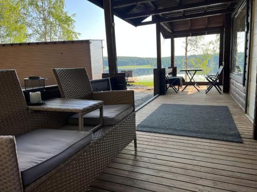 a patio with chairs and a table on a deck at Lake Cottage with sauna (near City) in Jyväskylä