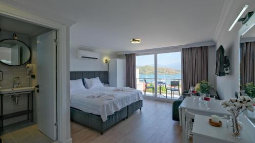 um quarto de hotel com uma cama e uma varanda em Miralya Suites em Fethiye