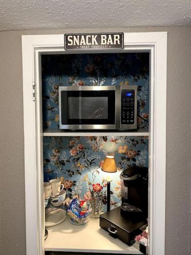a shelf with a microwave on top of it at Artist Condo in Beaumont