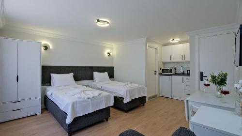 um quarto de hotel com duas camas e uma cozinha em Miralya Suites em Fethiye