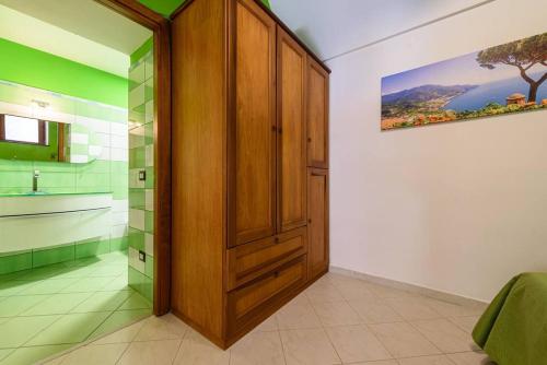uma casa de banho com um armário de madeira e um chuveiro em [Sorrento Coast] Villa with garden Il Glicine em Piano di Sorrento