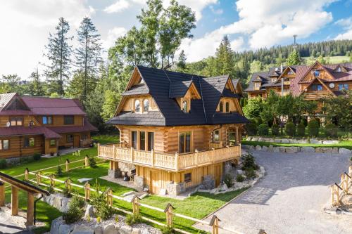 a log home with a black roof at udanypobyt Tatrzańskie Domy in Kościelisko