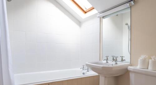 Un baño blanco con lavabo e inodoro. en Bull Pen, en Rusland