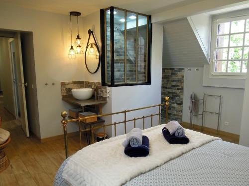 una camera da letto con un letto e due asciugamani di Le Cottage des 3 Pignons a Noisy-sur-École