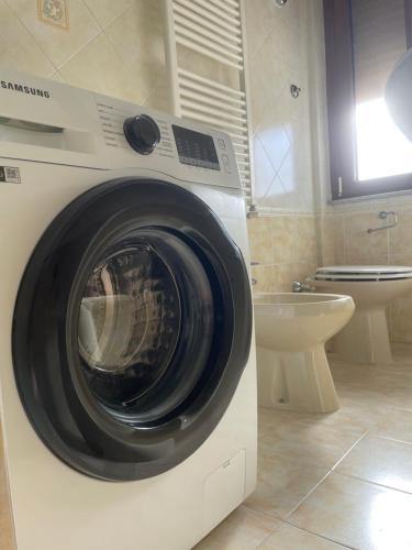 a washing machine in a bathroom with a toilet at Happy house in Civitavecchia