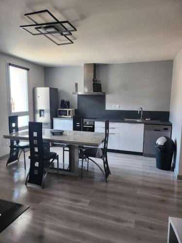 une cuisine avec une table et des chaises dans une pièce dans l'établissement Appartement sandonato, à Clermont-lʼHérault