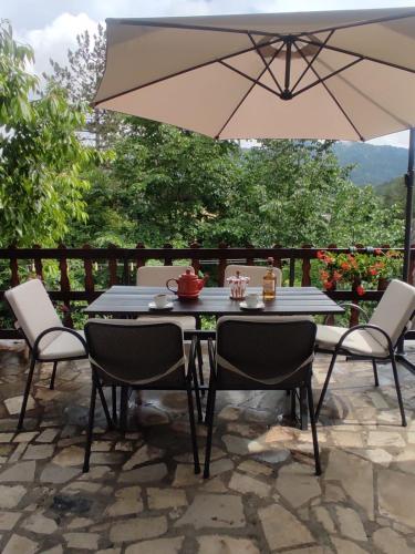 una mesa y sillas con una sombrilla en el patio en Kuća za odmor Iva, en Lič