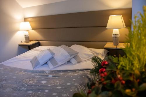 a bed in a hotel room with two lamps at Apartamenty nad Strumykiem in Brenna
