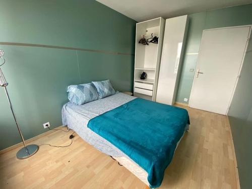 une chambre avec un lit avec une couverture bleue dans l'établissement Belle vue de Lognes- 15min Disney/ 5min gare / Parking gratuit, à Lognes