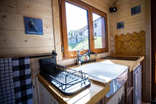 a small kitchen with a sink and a stove at L'encantada- Roulotte in Rieux