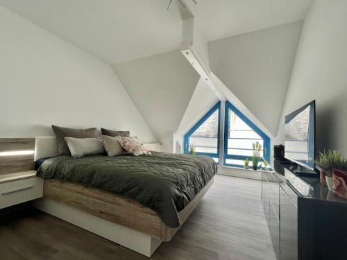 um quarto com uma cama e 2 janelas grandes em Premium FeWo - Blick auf Felsenkirche & Schloss - Traveller AWARD 2024 em Idar-Oberstein