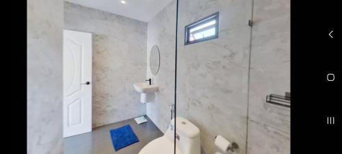 a bathroom with a toilet and a glass shower at kadena villa in Koh Samui 