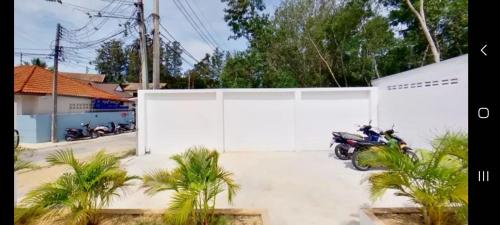 a motorcycle parked in a parking lot next to a white wall at kadena villa in Koh Samui 