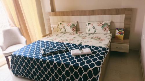 a bedroom with a bed with a blue and white comforter at Blue Mans Rooms in Vrindāvan