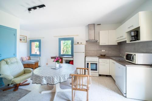 une cuisine avec une table et des chaises dans une pièce dans l'établissement Evasion Céret - Appt champêtre proche centre-ville, à Céret