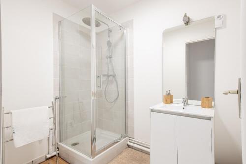 a white bathroom with a shower and a sink at L'Escapade Marine - Superbe appt pour 4 in Calais