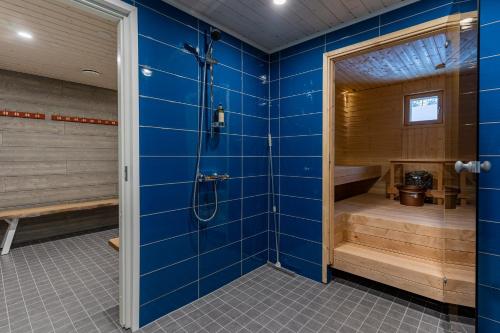 y baño azul con ducha y bañera. en Igloo Glamping LakeLand Camp en Imatra
