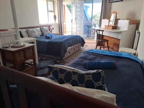 - un salon avec deux lits et un canapé dans l'établissement Ryans Surf Cabin, à Jeffreys Bay