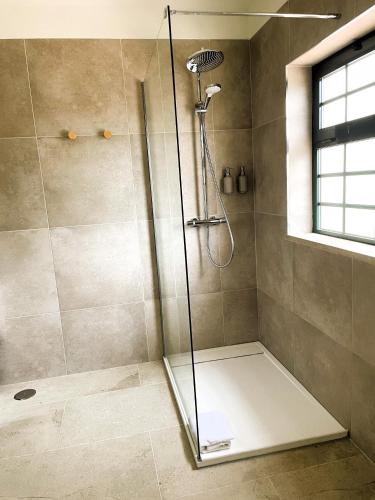 a shower with a glass door in a bathroom at Casa Velha Apartments - Adults friendly in Albufeira