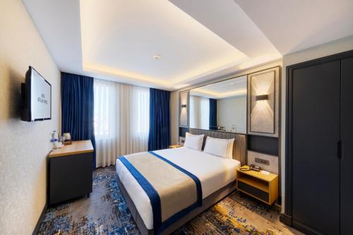 una camera d'albergo con letto e TV di AHG Atlas Hotel Taksim a Istanbul