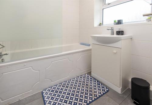 a bathroom with a white tub and a sink and a mirror at A home away from home - Derby in Derby