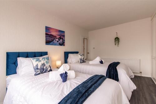 twee bedden in een kamer met wit en blauw bij A home away from home - Derby in Derby