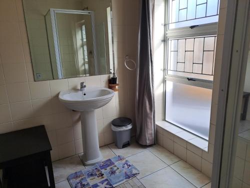 La salle de bains est pourvue d'un lavabo et d'un miroir. dans l'établissement Ryans Surf Cabin, à Jeffreys Bay