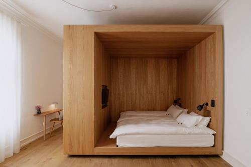 Bett in einem Holzrahmen in einem Zimmer in der Unterkunft Das Edith in Stuttgart