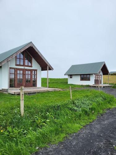 une petite maison dans un champ à côté d'une route dans l'établissement Hólar Countryside Cabin 2, à Selfoss