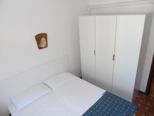 リニャーノ・サッビアドーロにあるCondominio Mareの白いベッドルーム(ベッド1台、キャビネット付)