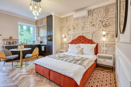 a bedroom with a large bed and a kitchen at The Doors Luxury Apartment in Mosonmagyaróvár