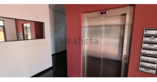 a metal elevator in a room with a red wall at Vacaciones perfectas. in Paterna