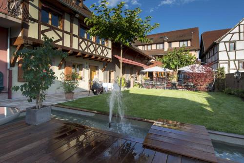 a fountain in the middle of a yard at Hôtel Restaurant La Charrue in Sand