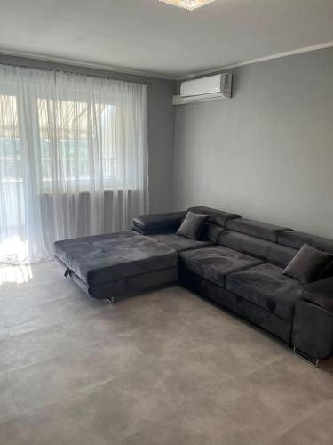 uma sala de estar com um grande sofá em frente a uma janela em Charmante Ferienwohnung mit Klimaanlage ! em Mainaschaff
