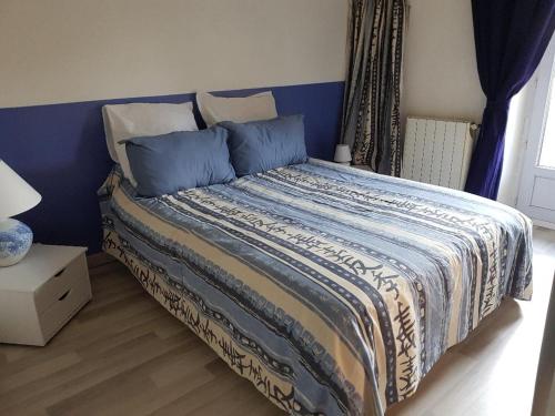 Schlafzimmer mit einem Bett mit blauem Kopfteil in der Unterkunft Maison au Pied du Pont du Gard in Remoulins