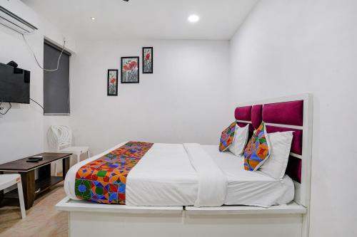 a bedroom with a bed and a desk and a television at FabExpress VYS Inn in Pune