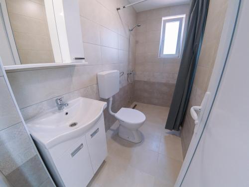 a white bathroom with a sink and a toilet at Smeštaj Milutinn in Soko Banja